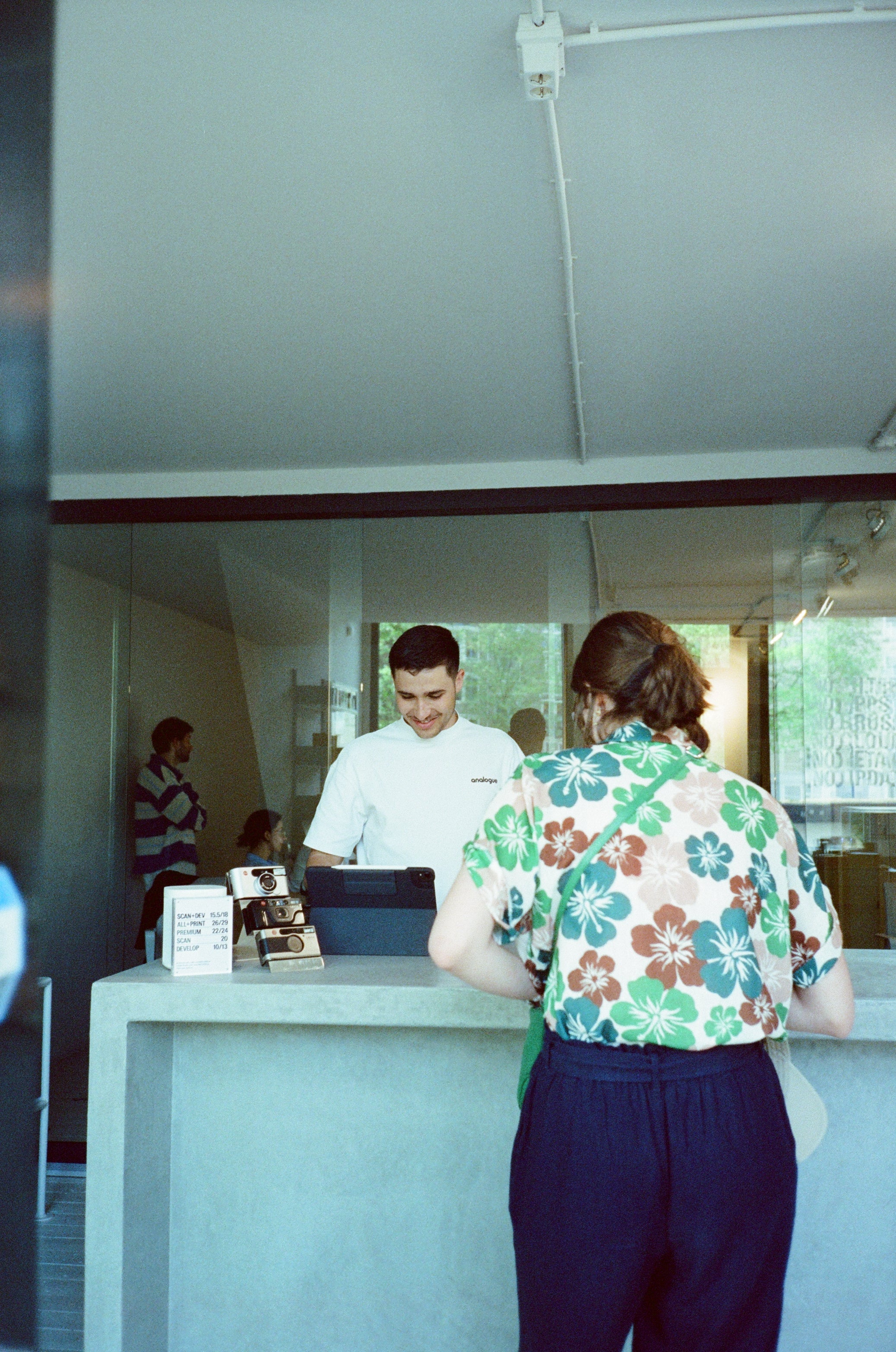 Photographer using Mira Color 800 film in low-light urban setting, capturing vibrant images