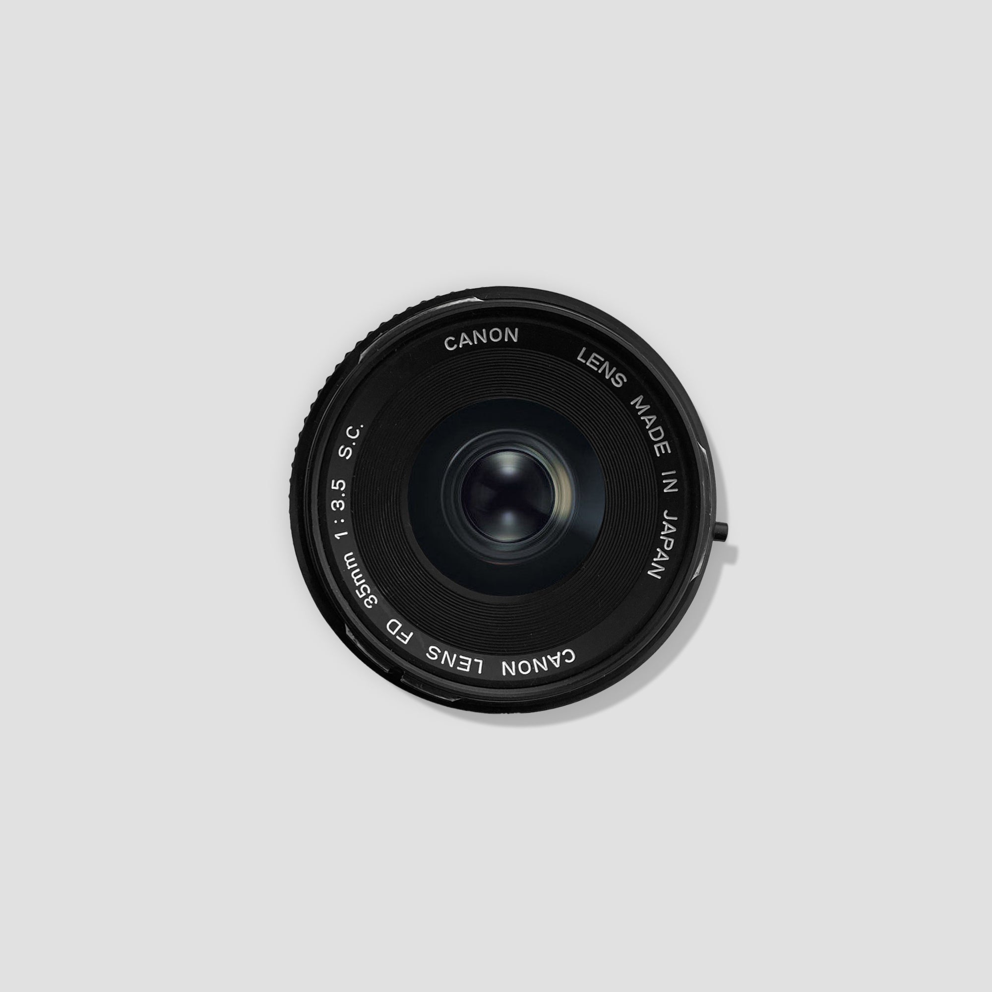 Canon FD 35mm f/3.5 lens from the front angle, highlighting its compact design