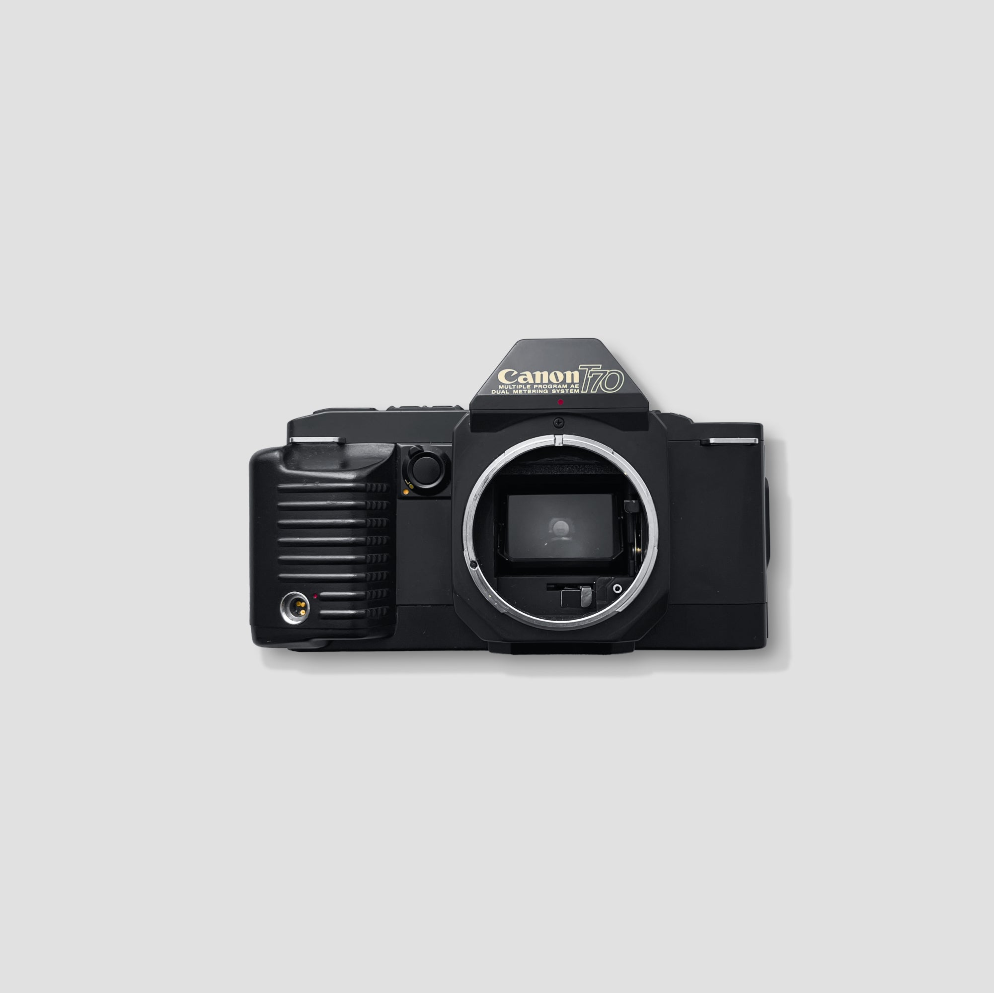 Front view of Canon T70 vintage SLR camera with FD lens attached, showing classic design.
