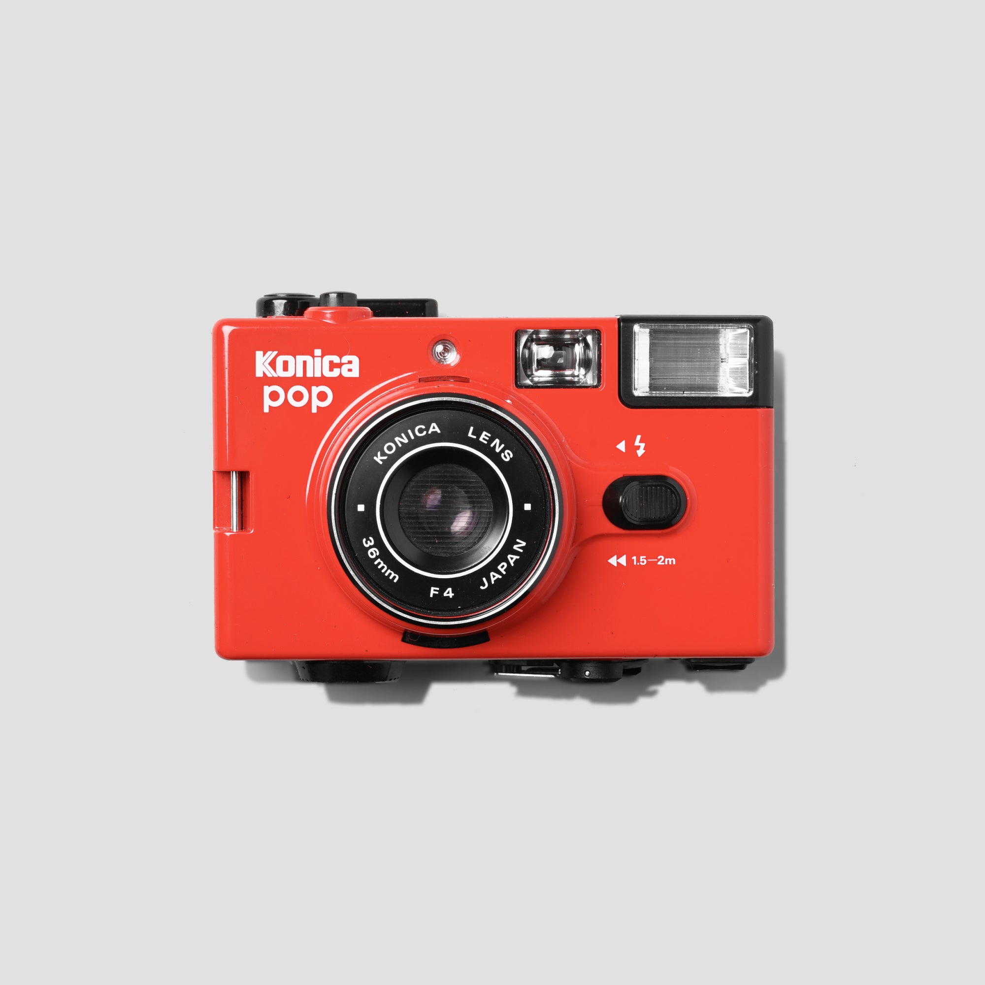 Close-up of the Konica Pop Red vintage film camera highlighting its vibrant color and sleek design.