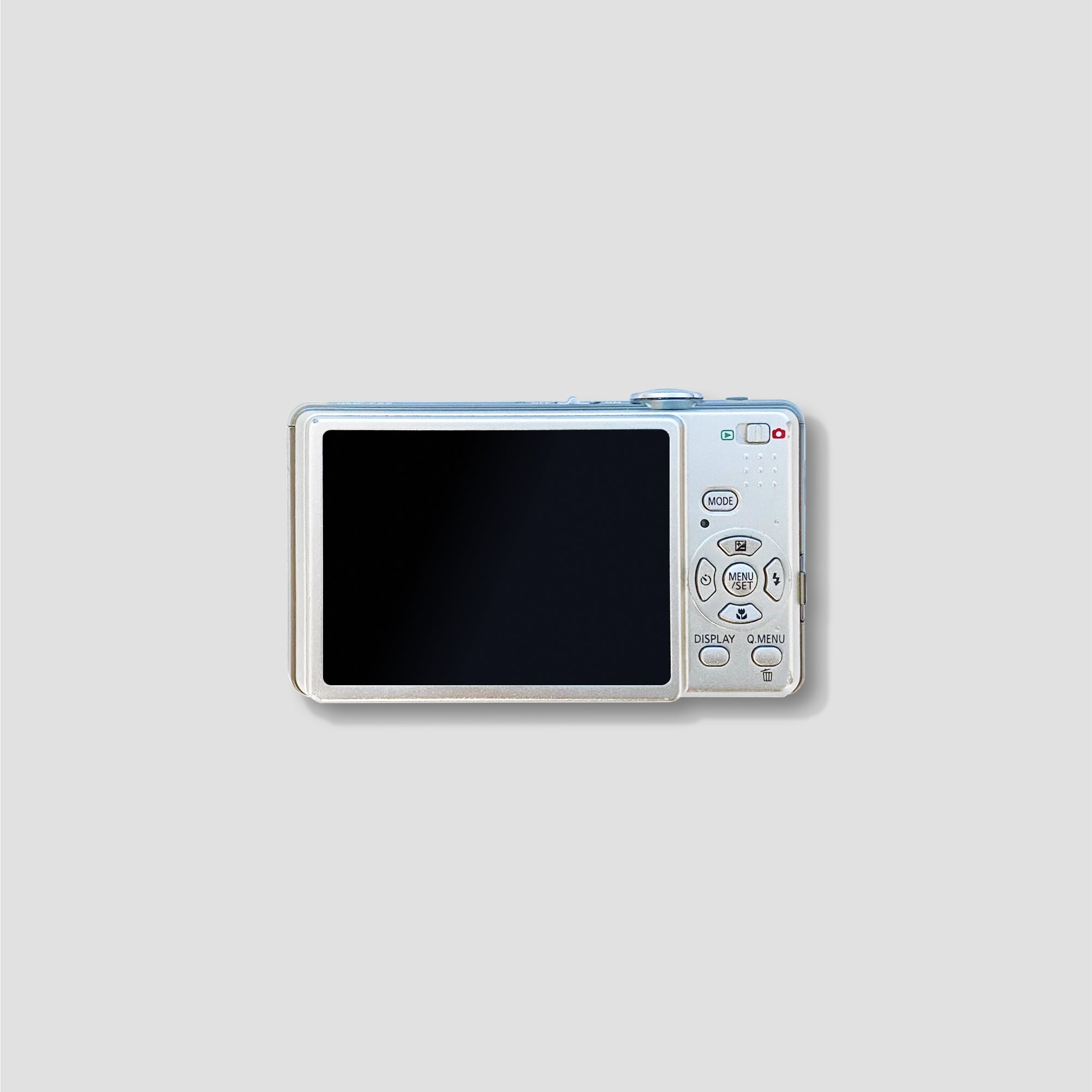 Panasonic Lumix DMC-FS7 placed on a table with travel accessories