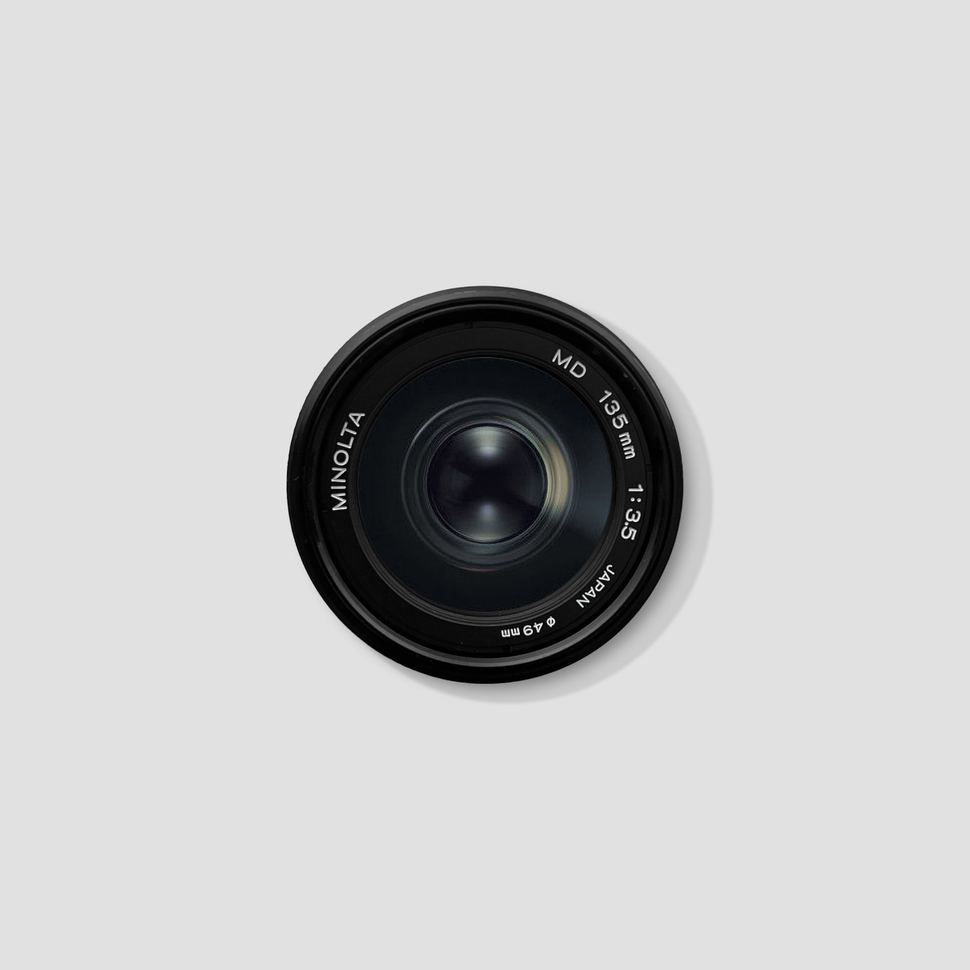Side view of Minolta MD 135mm f/3.5 lens showing focus ring and markings