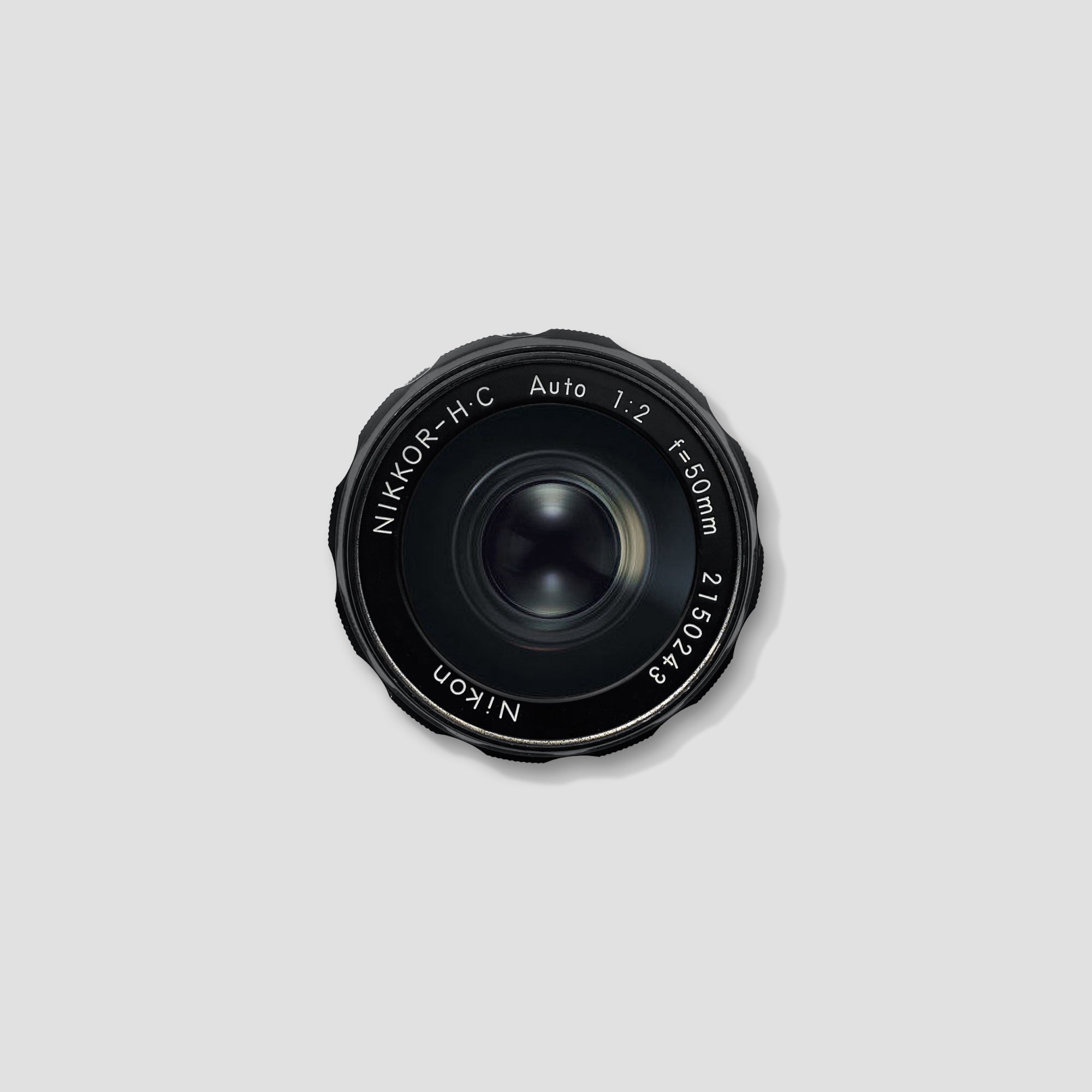 Close-up of Nikon Nikkor-H.C 50mm f/2 lens demonstrating its classic design and manual focusing mechanism.