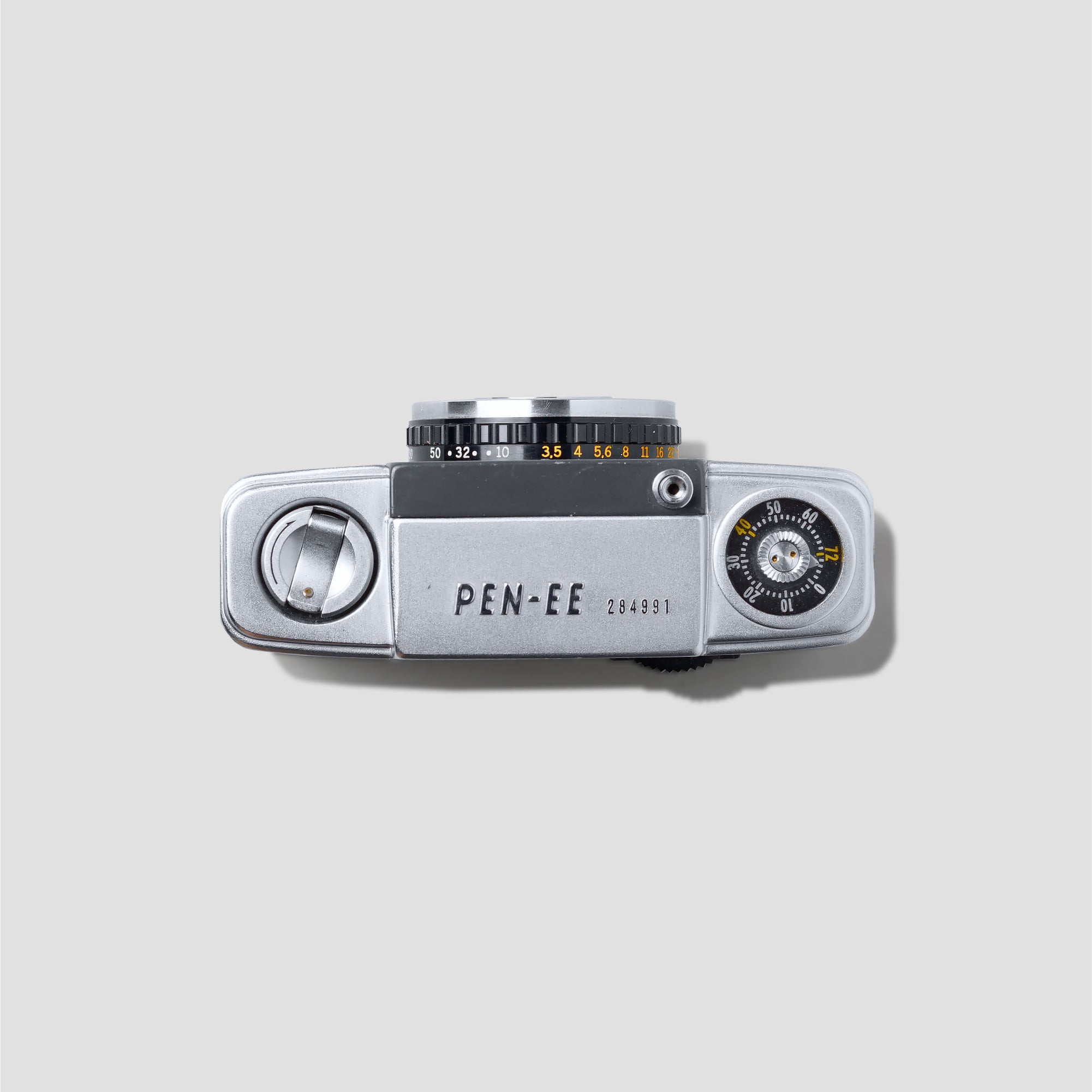 User holding Olympus Pen-EE camera capturing street scenes during travel