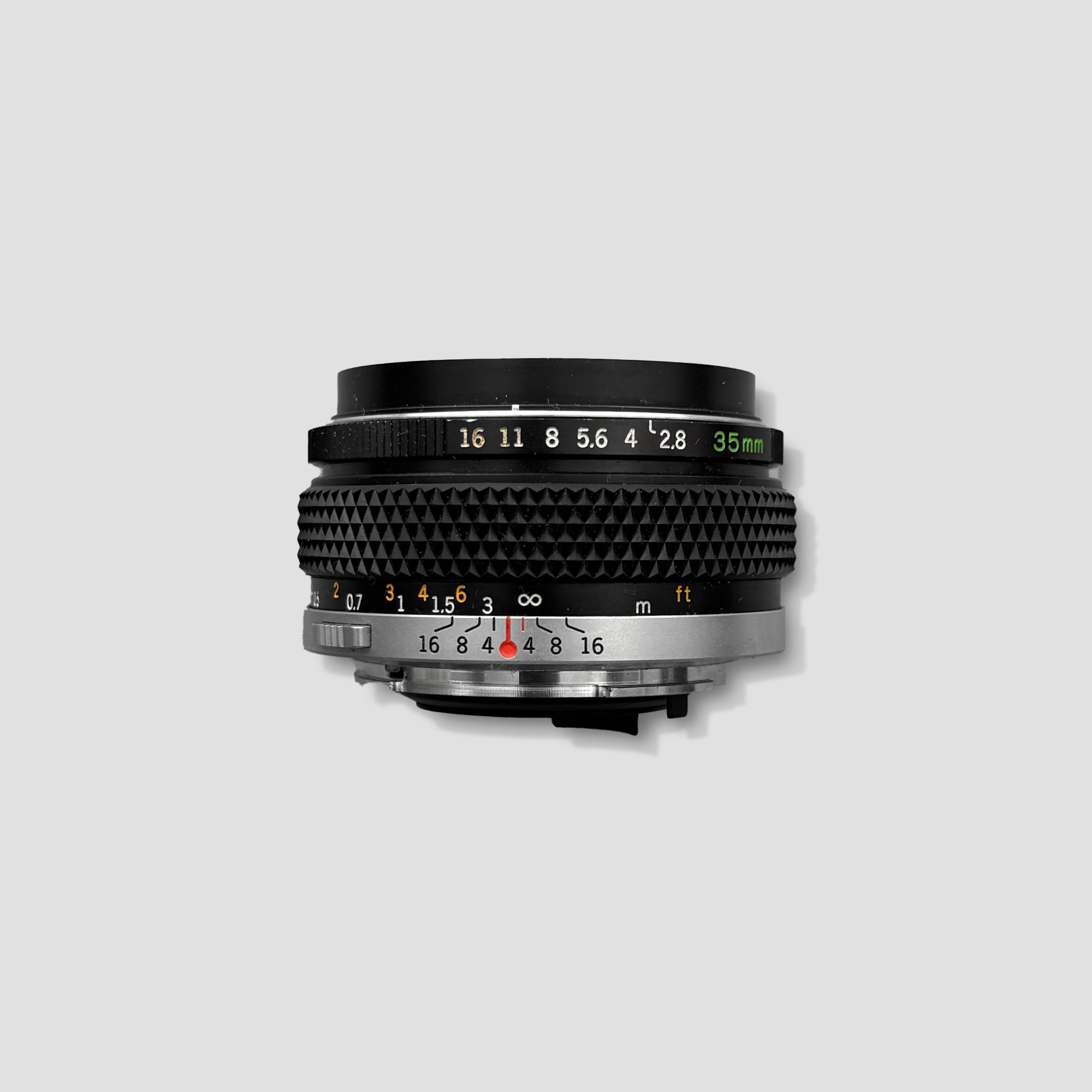 Olympus OM 35mm f/2.8 wide-angle lens mounted on Olympus OM camera, showcasing its compact size and build quality
