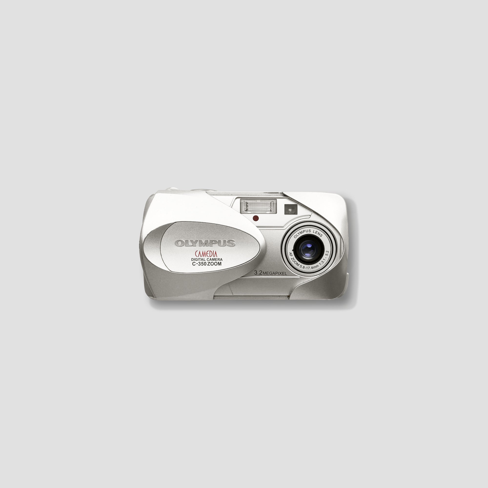 Person holding Olympus C-350 compact digital camera outdoors
