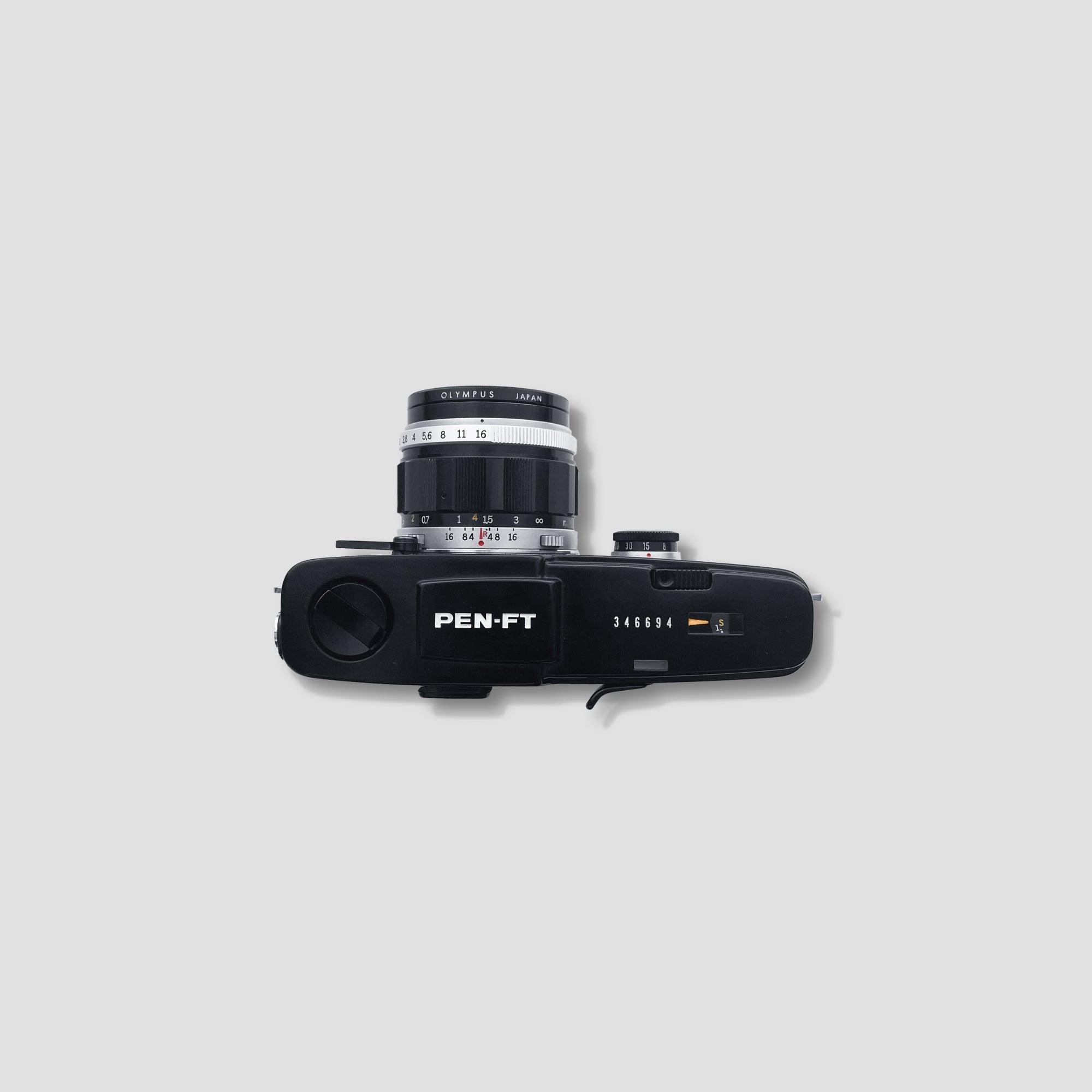 Olympus Pen FT in use, capturing a cityscape with film rolls nearby