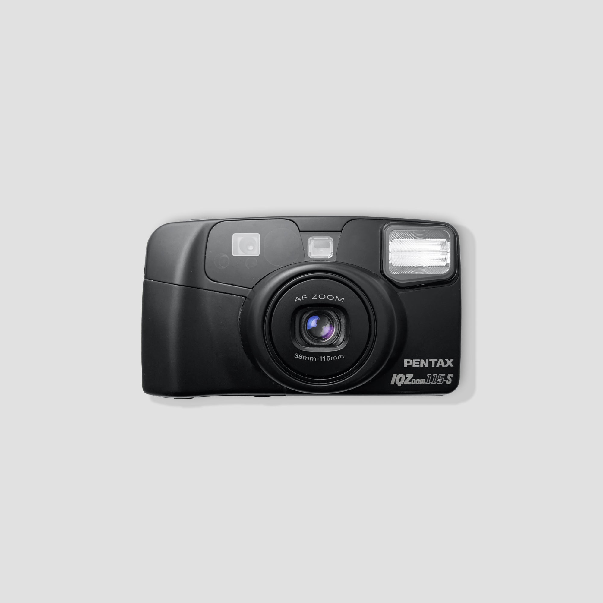 Pentax IQZoom 115-S compact film camera with a scenic backdrop