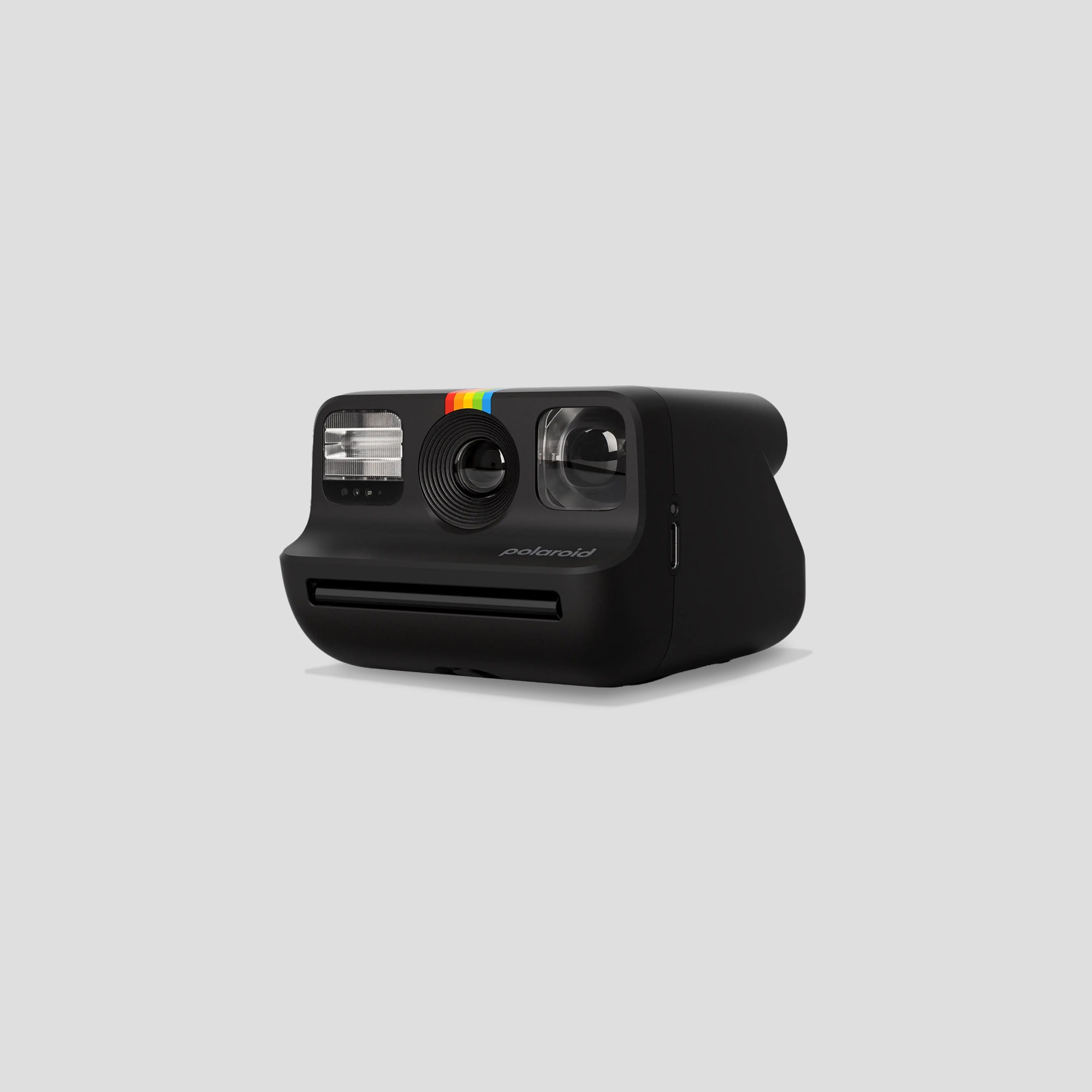 User  taking a selfie with the Polaroid Go 2 in a vibrant setting.