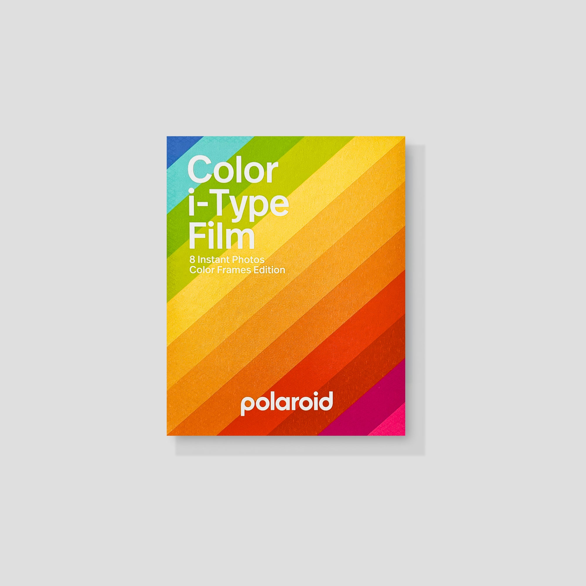 Polaroid camera with colorful framed instant photos on a table
