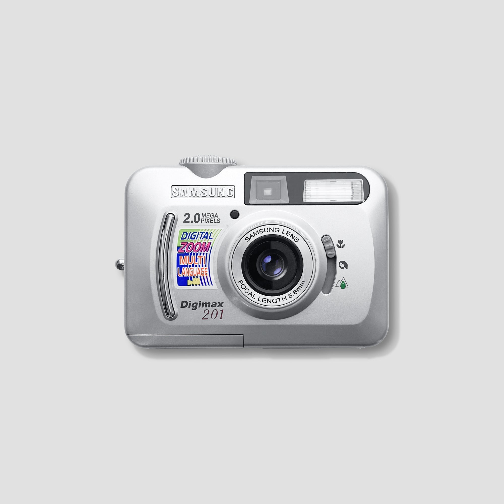 A top-down view of the compact camera showcasing its 2x optical zoom lens and matte silver finish.