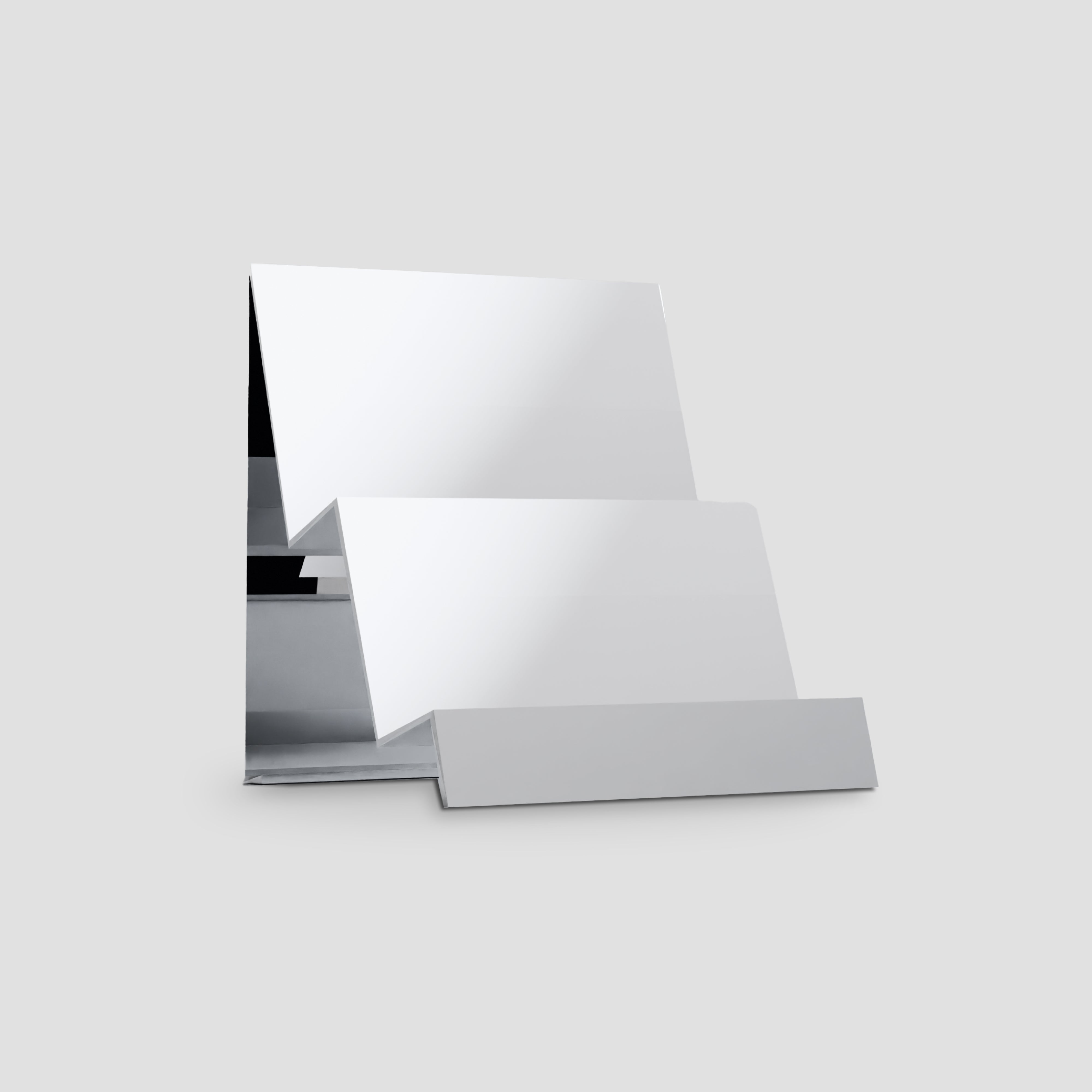 Premium reflective camera display stand from the side, highlighting its two-step design.