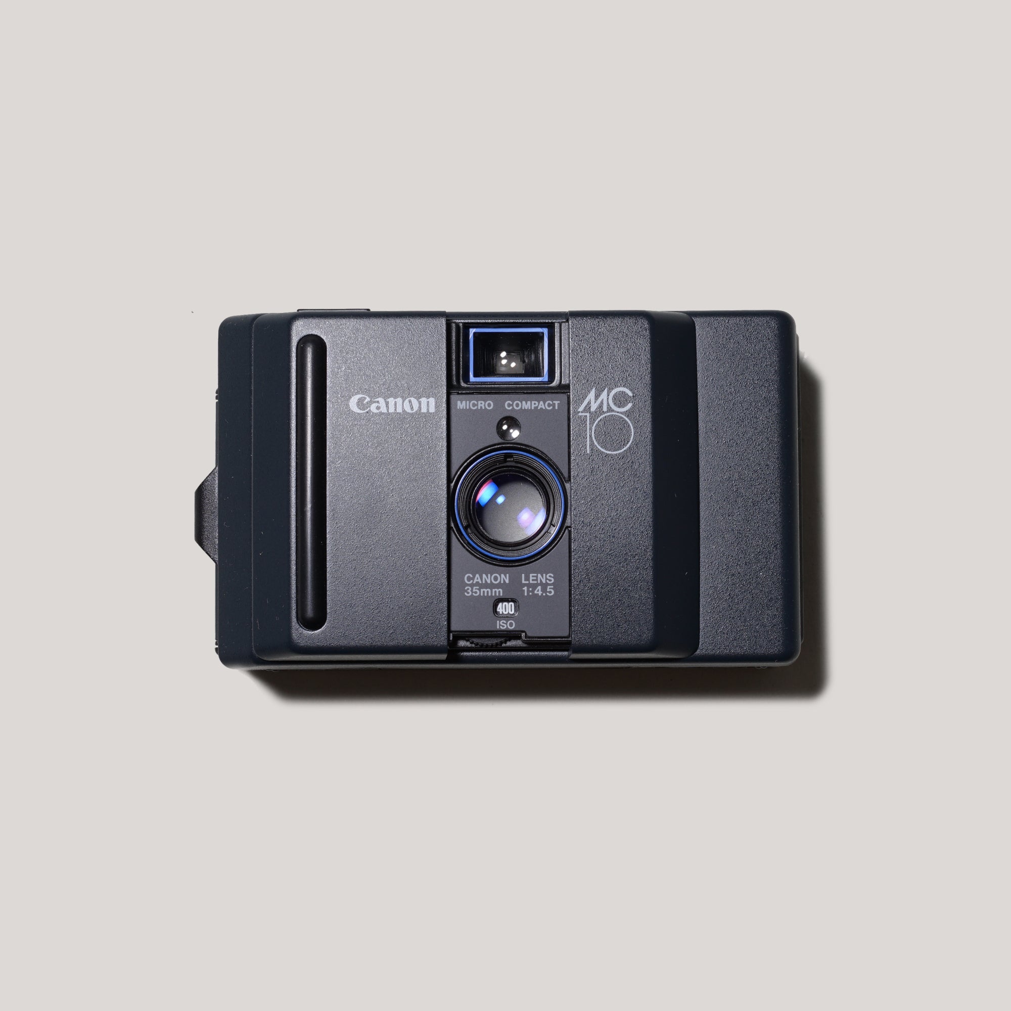 Front view of the Canon MC 10 pocket film camera with autofocus feature.