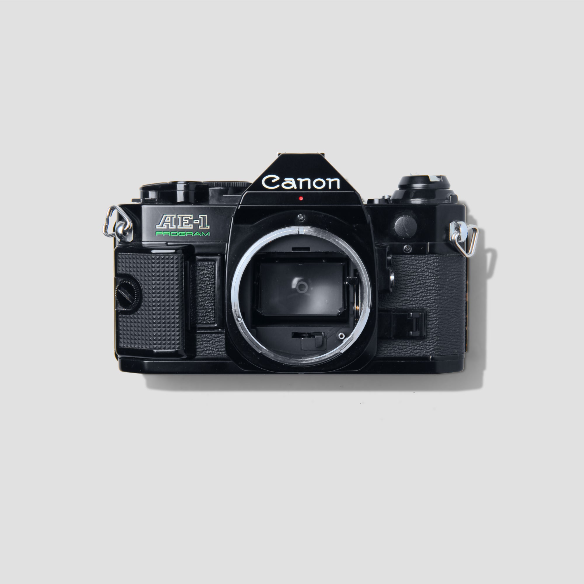 Canon AE-1 Program Black vintage film camera from the front view, showcasing its design and features.