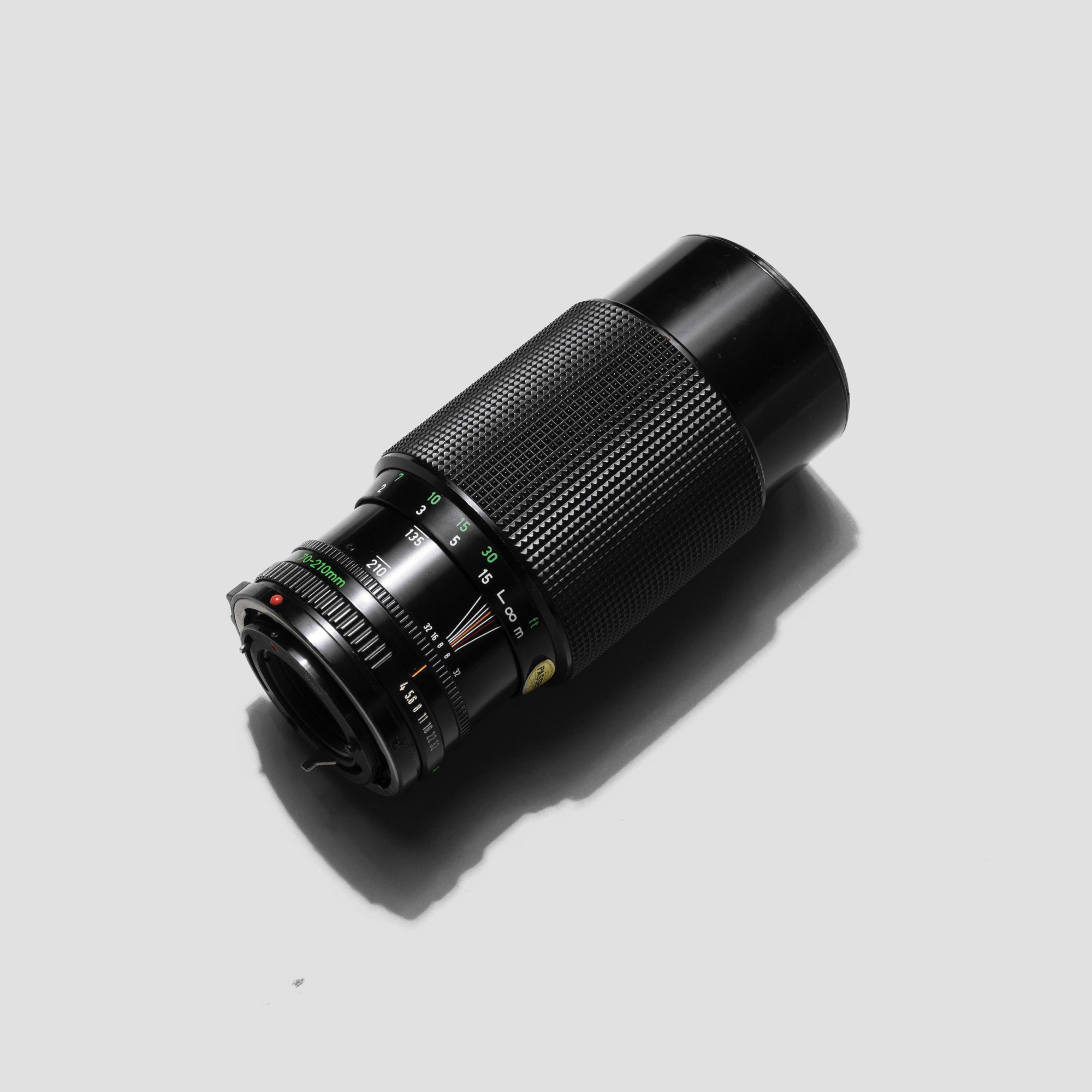 Canon FD 70-210mm f/4 telephoto lens mounted on a camera, showing its zoom range