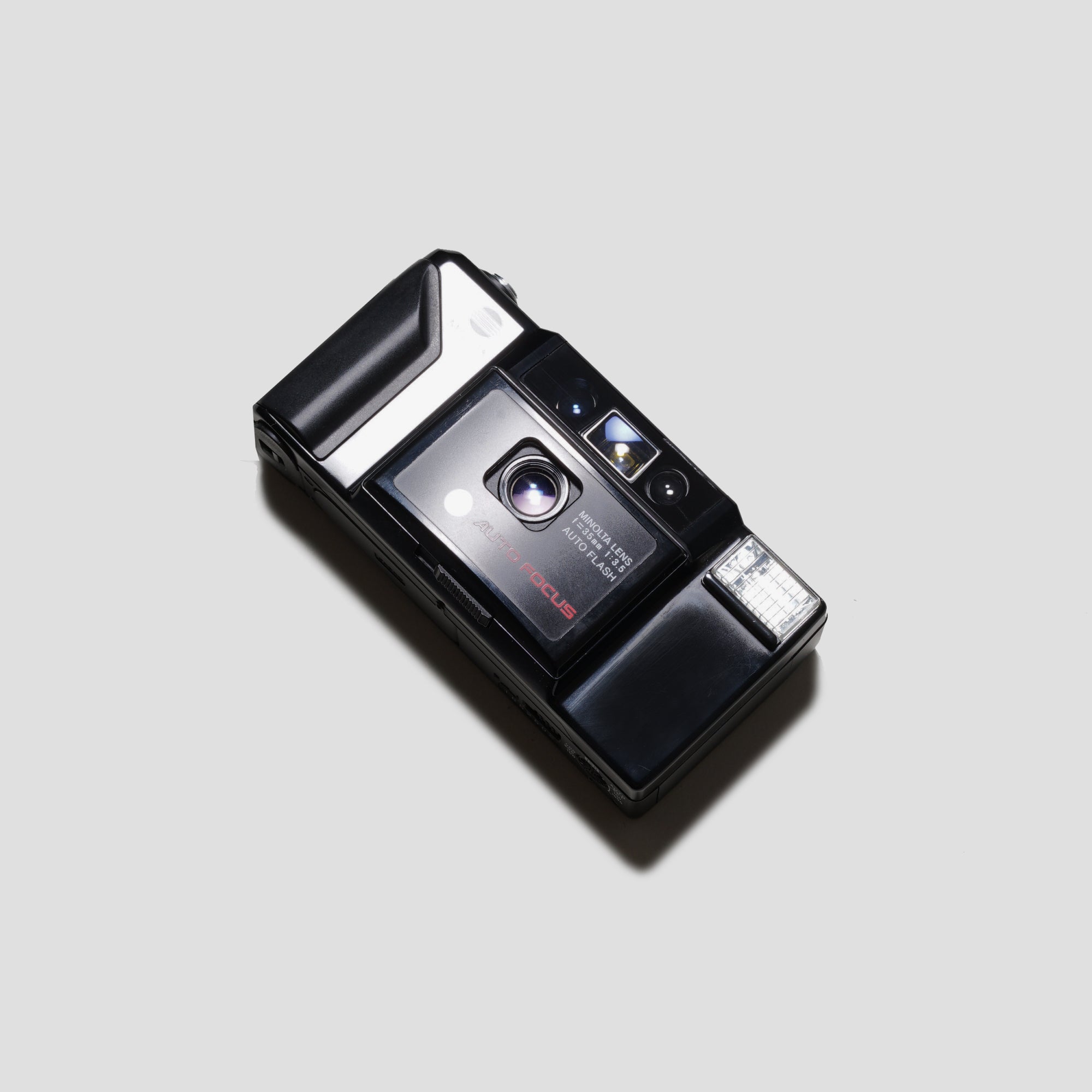 Front view of Minolta AF-E Black vintage compact camera showing all-black design