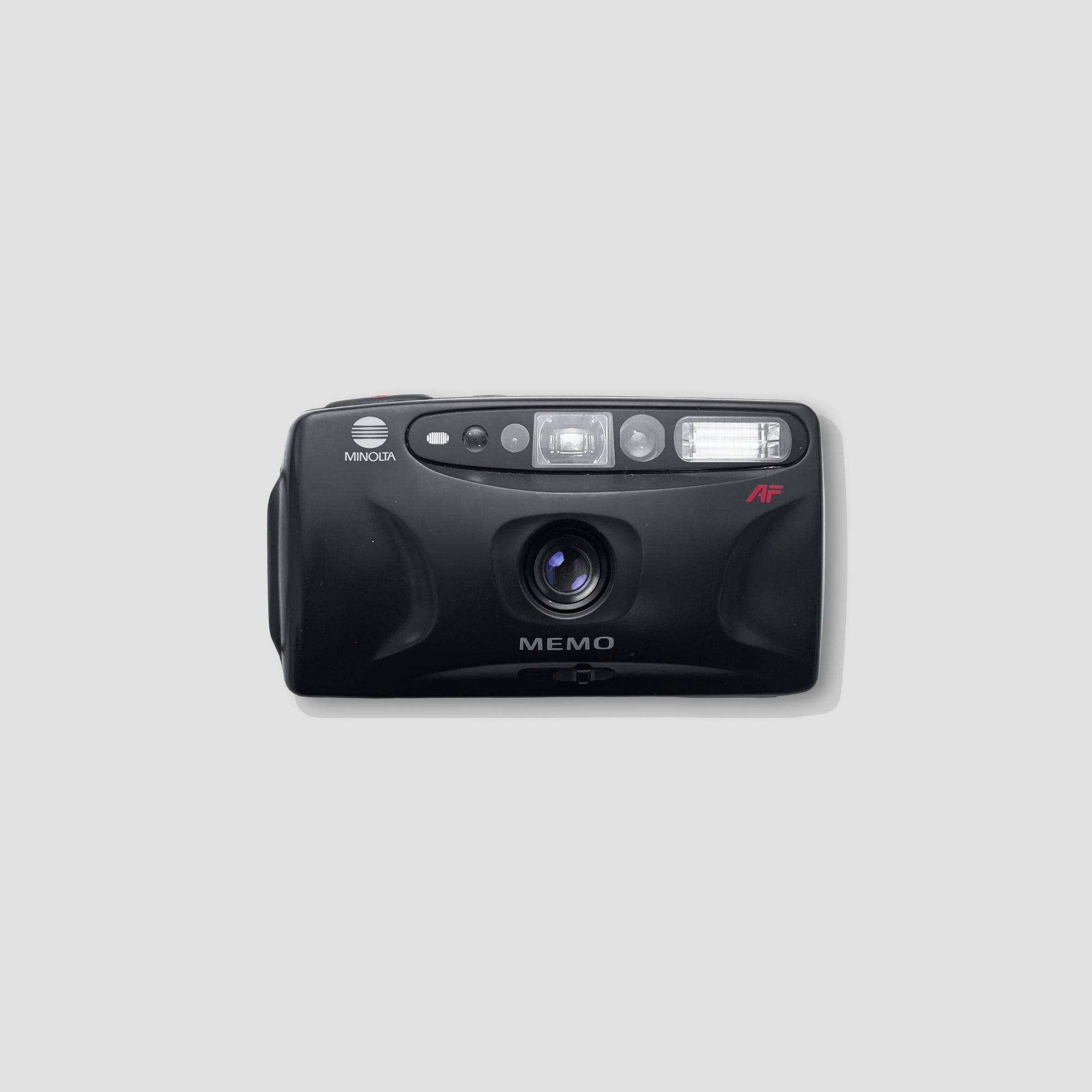 Close-up of the Minolta Memo film camera showing its minimalist body and fixed lens