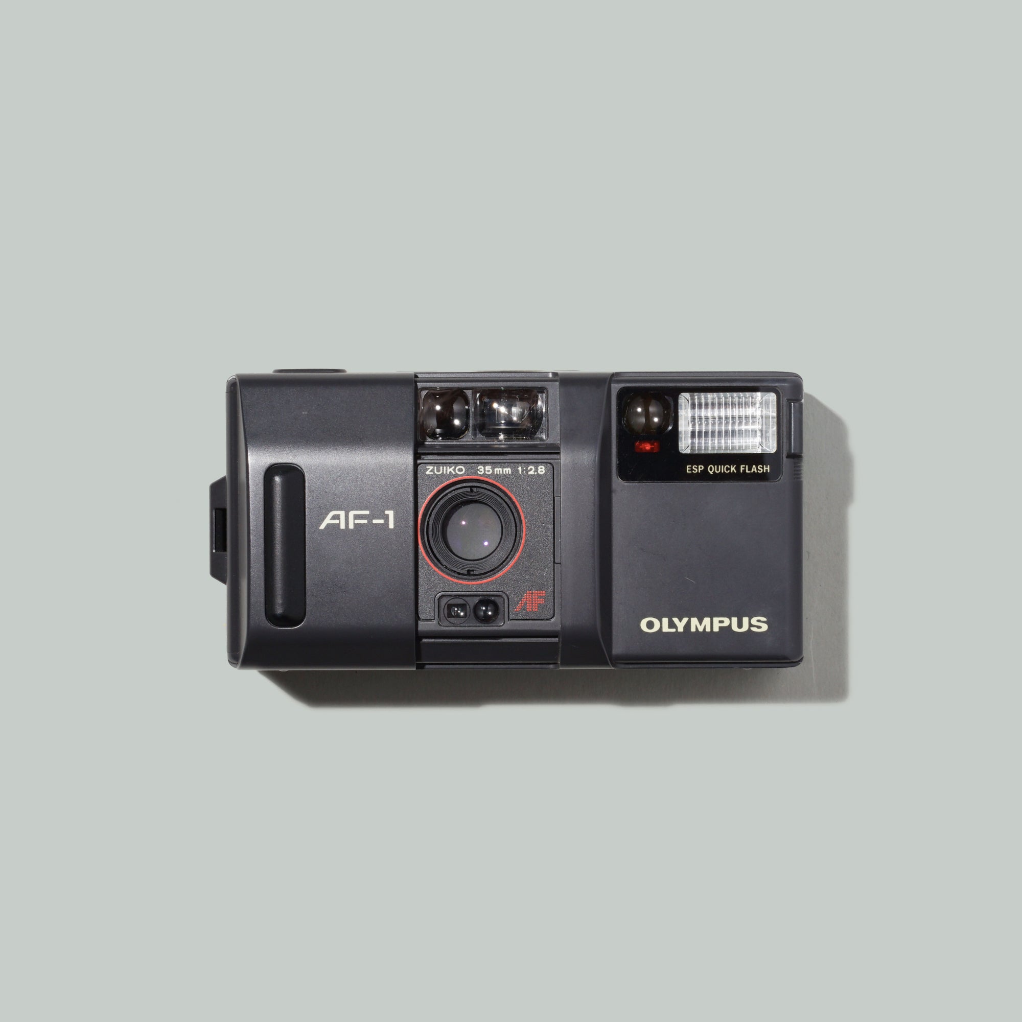 Close-up of Olympus AF-1 camera with Zuiko lens showing compact design