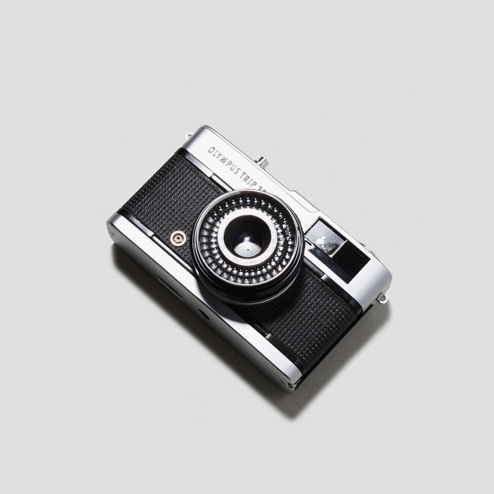 Olympus Trip 35 camera in a scenic outdoor setting, showcasing its sleek design and compact size.