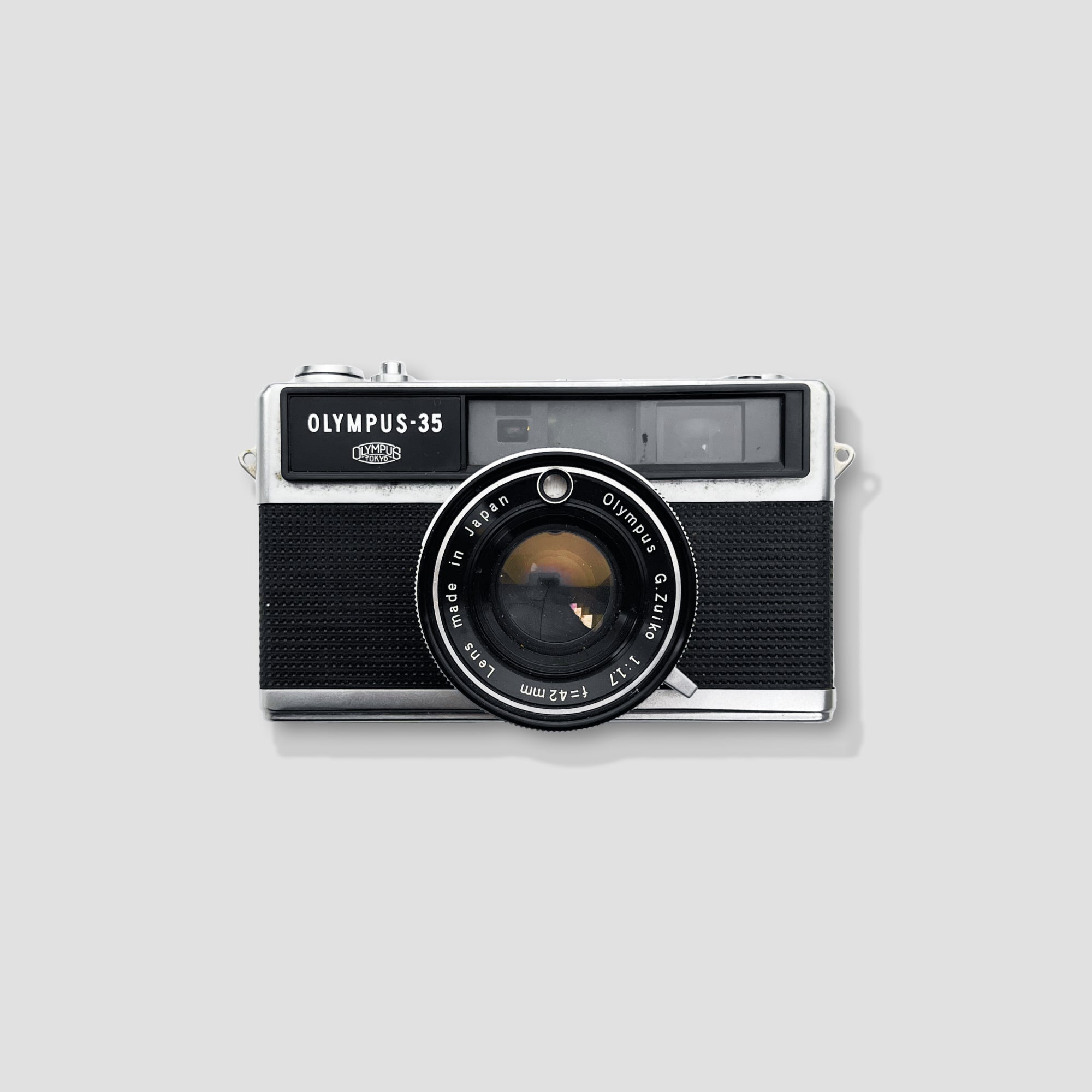 Olympus 35 LC camera with a close-up of its 42mm f/2.8 lens, highlighting its compact size and vintage design.