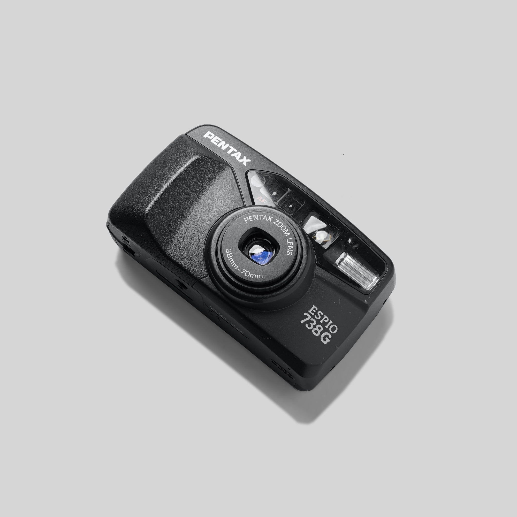 Travel photographer using the Pentax Espio 738G in scenic outdoor setting