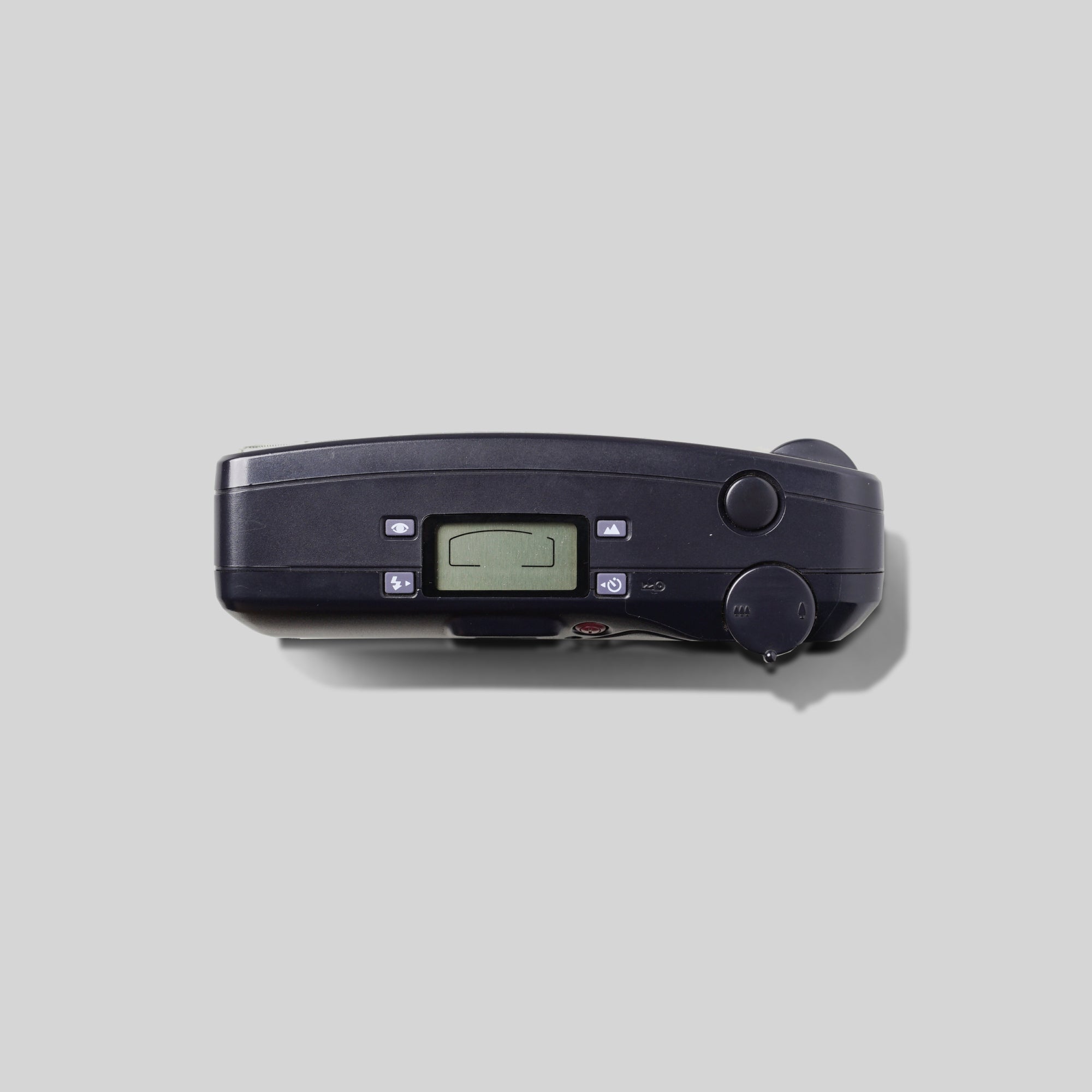 Camera held in hand with wrist strap, highlighting portability and user-friendly size for film photography.